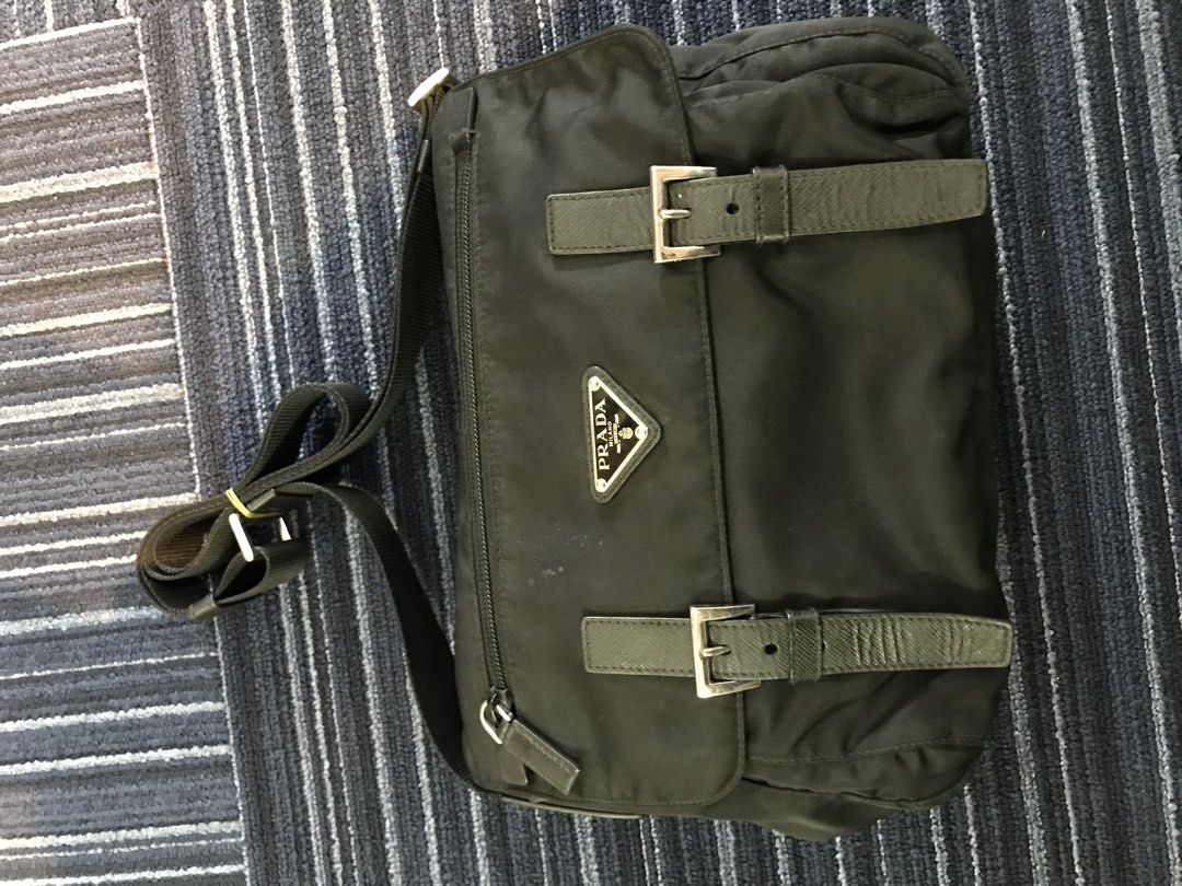 Prada Nylon Messenger Bag Black (Category: Luxury Bags & Wallets) located in Bamban. Submitted by ukaythriftedkoto (Listing ID 1441077145, Image 1). Description: - Authentic black Prada messenger bag - Durable nylon material with leather trim - Secure buckle closures on front flap - Adjustable shoulder strap for comfort - Spacious zippered main compartment - Convenient exterior zip pocket - Perfect for everyday carry.