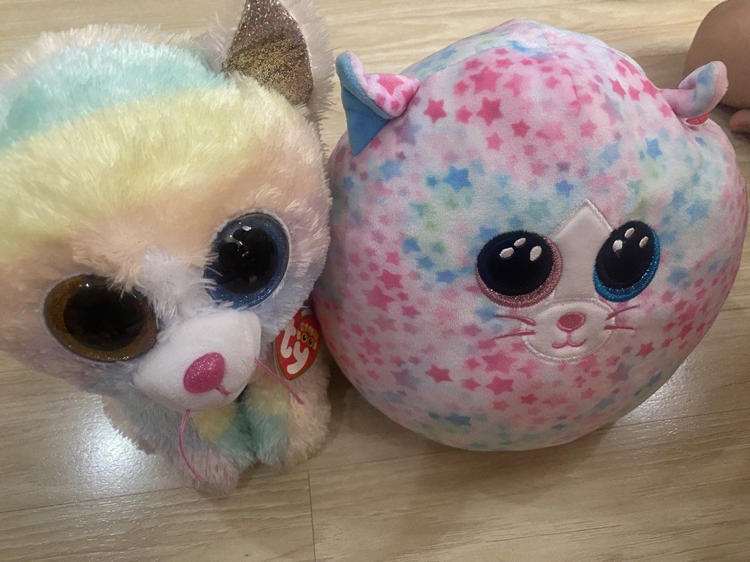 Rainbow Cat & Pink Star Squishmallow (Category: Plushies & Soft Toys) located in Makati City. Submitted by ann.declutter (Listing ID 1441023673, Image 1). Description: - Adorable rainbow cat plushie with big sparkly eyes. - Authentic Ty brand tag included. - Round, soft pink plushie adorned with blue and purple stars. - Both plushies are incredibly soft and cuddly. - Ideal gifts for children or must-have additions for collectors..