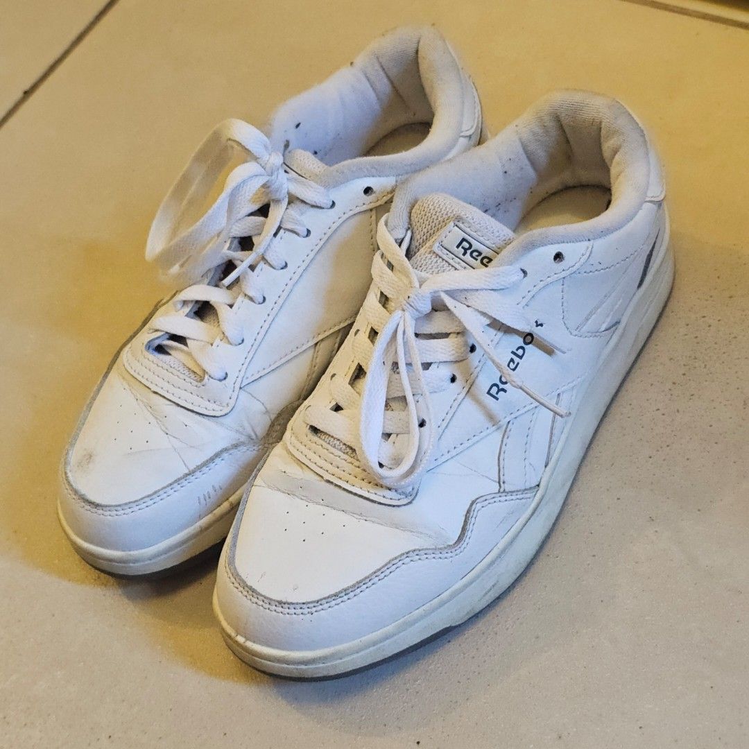 Reebok White Sneakers (Category: Sneakers) located in Silang. Submitted by monpeanut (Listing ID 1441025669, Image 1). Description: - Classic white Reebok low-top sneakers - White laces - Dark grey soles with Reebok branding - Visible scuffs and marks on white leather - Perfect for everyday casual wear.