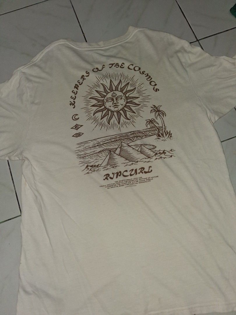 Rip Curl Relaxed Fit Graphic T-Shirt Size L (Category: Tshirts & Polo Shirts ) located in Manila. Submitted by aguilarben29573 (Listing ID 1441094326, Image 2). Description: - Cream-colored Rip Curl T-shirt - Size: Large (L) - Relaxed fit for comfort - Features a unique sun and landscape graphic print on the back - Small Rip Curl logo detail on the front chest - Made in Bangladesh - Ideal for casual outings and everyday wear.