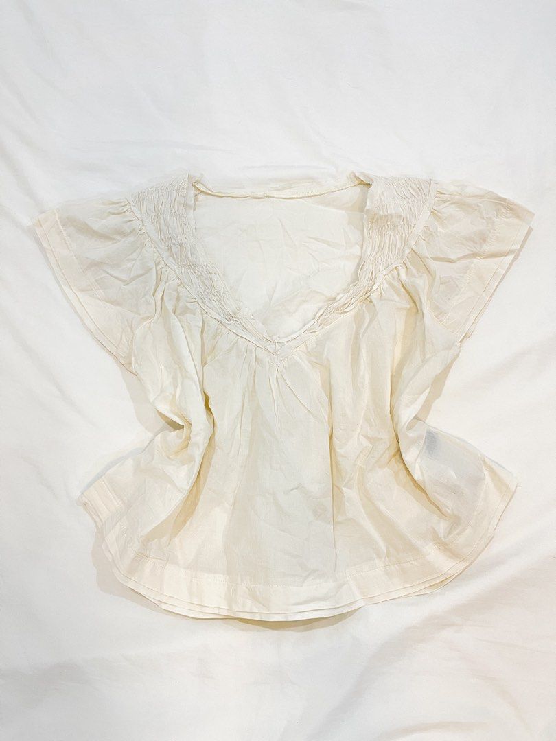 SHEIN Cream Smocked V-Neck Flutter Sleeve Top (Category: Blouses) located in San Isidro. Submitted by kosfei (Listing ID 1441113862, Image 2). Description: fits S-M help me clean up my closet >< all items are pre-loved, most are unused or worn only once! visit my ig @riclauset for more info ^^ .