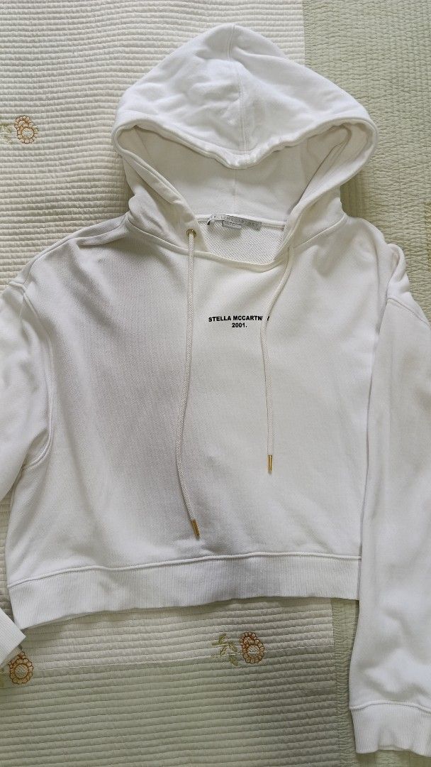 Stella McCartney 2001 Hoodie White (Category: Coats, Jackets and Outerwear) located in Cebu City. Submitted by mcmapio (Listing ID 1441049821, Image 1). Description: - White Stella McCartney hoodie - Cropped style - Drawstring hood - Features 'STELLA MCCARTNEY 2001.' text on the front - Made in Portugal - Size 38.