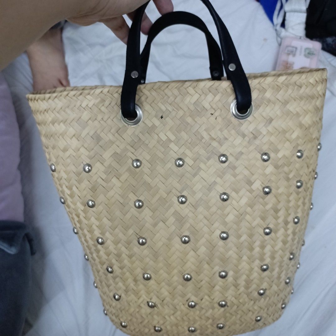 Straw Tote Bag with Studs and Leather Handles (Category: Tote Bags) located in Manila. Submitted by fierceflower-b0d4 (Listing ID 1440980958, Image 1). Description: - Cute straw tote bag - Decorated with silver studs all over - Black leather handles - Some signs of wear on the bottom - Interior leather logo tag - Great for summer outings.