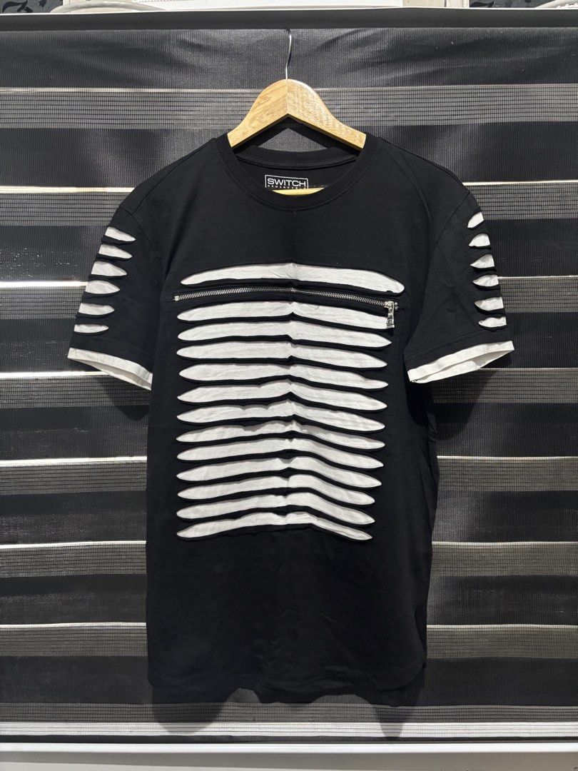 SWITCH REMARKABLE Black Cut-out T-shirt Size M (Category: Tshirts & Polo Shirts ) located in Manila. Submitted by jonard2297 (Listing ID 1441053461, Image 1). Description: - Brand: SWITCH REMARKABLE - Color: Black - Size: Medium (M) - Design: Unique cut-out details with white lining - Features: Front zipper, cut-out sleeves - Material: 100% Cotton.