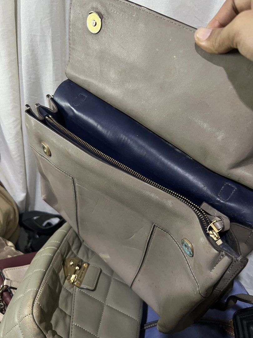 Tory Burch Grey Leather Tote Bag (Category: Luxury Bags & Wallets) located in Manila. Submitted by mightylion-ce6ea7 (Listing ID 1440968374, Image 3). Description: - Grey leather Tory Burch tote bag - Top handles and detachable shoulder strap - Magnetic snap closure on flap - Interior zippered compartment - Gold hardware - Note: Some scuffs and marks on the leather.