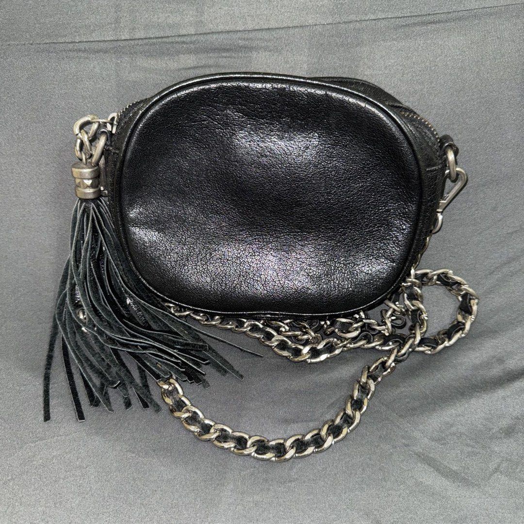 Valentino Crossbody Bag (Category: Luxury Bags & Wallets) located in Calasiao. Submitted by jafaith_man (Listing ID 1441085844, Image 2). Description: Valentino by Mario Valentino (the licensed Italian leather goods brand distinct from Valentino Garavani) Distinct oval/camera-bag shape, quilted central “V” design stitched into the front panel, silver-tone brand plaque, a coordinating leather tassel charm, and a signature woven chain-and-leather s