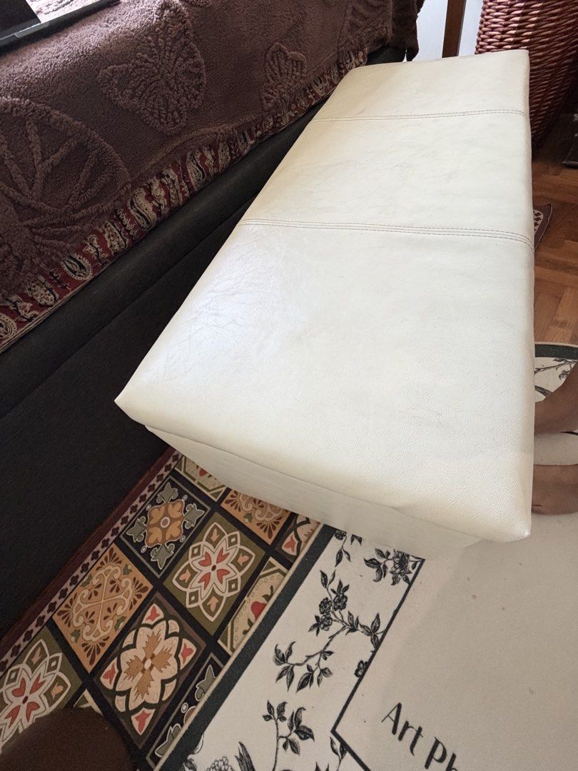 White Faux Leather Storage Ottoman Bench with Wooden Legs (Category: Chairs) located in Singapore. Submitted by priyanka_chatz (Listing ID 1441049454, Image 2). Description: - White faux leather storage ottoman - Hinged lid for easy access to storage - Minor exterior marks and a small pink stain (as pictured) - Lined interior - Stable wooden legs - Versatile for extra seating or storage in any room L - 99 cm B - 39 cm H - 45 cm.