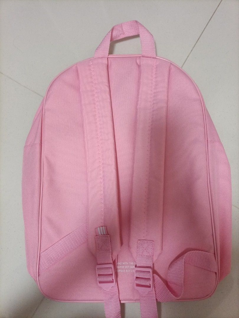 Authentic Adidas Pink Backpack (Category: Backpacks) located in Singapore. Submitted by iris_rae (Listing ID 1436046120, Image 2). Description: - Pink Adidas backpack - Features the Adidas trefoil logo - Adjustable shoulder straps - Top handle - Suitable for everyday use - Minor yellowing marks on logo comes with free pink doraemon bag charm Abit of yellowing on the doraemon.