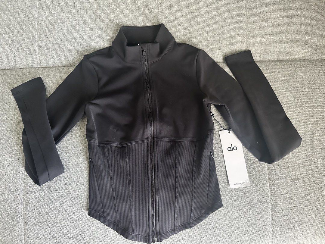 Alo Yoga Corset Zip-Up Jacket (Category: Activewear) located in Quezon City. Submitted by apujooz (Listing ID 1435957184, Image 3). Description: Authentic Brand New Black zip-up jacket from Alo Yoga. Features a high collar and a ribbed panel across the midsection. The jacket has a full-length zipper and long sleeves. The Alo logo is visible on the back and on the tag. Size is XS/TP/ECH..