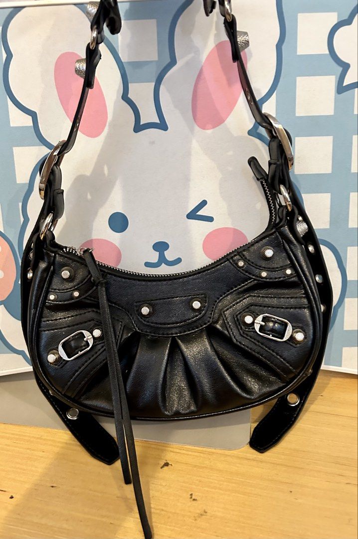 BAG OF PARODY (Category: Shoulder Bags) located in Quezon City. Submitted by asiaco (Listing ID 1435997646, Image 1). Description: Black shoulder bag with silver hardware. Features a curved shape, pleated details, and studded accents. Adjustable straps, zip closure, and leather tassel. Very nice for parties and nights out 🥂if you can’t afford balenciaga, this one is its closest cousin. .