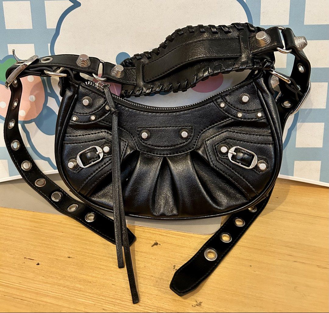 BAG OF PARODY (Category: Shoulder Bags) located in Quezon City. Submitted by asiaco (Listing ID 1435997646, Image 2). Description: Black shoulder bag with silver hardware. Features a curved shape, pleated details, and studded accents. Adjustable straps, zip closure, and leather tassel. Very nice for parties and nights out 🥂if you can’t afford balenciaga, this one is its closest cousin. .