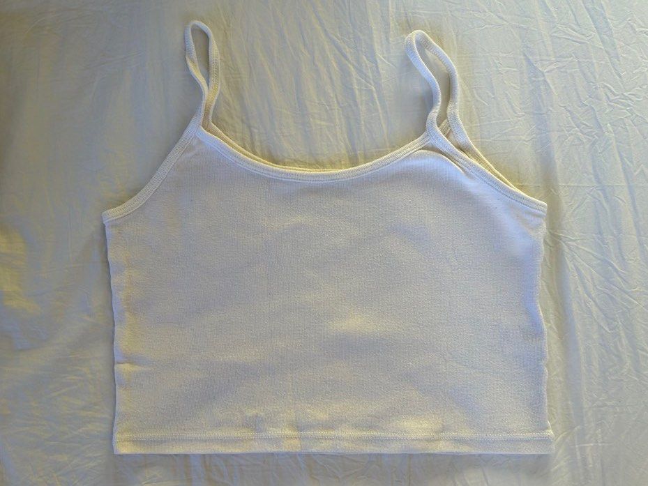 Brandy Melville White Cropped Tank Top (Category: Sleeveless) located in Makati City. Submitted by swedishcandy (Listing ID 1436096866, Image 1). Description: - Brand: Brandy Melville - Style: Tank top - Color: White - Scoop neck, spaghetti straps, ribbed knit fabric, curved hem - Perfect basic for layering or wearing on its own..