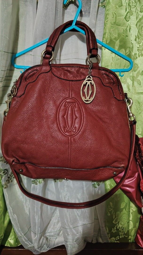 Cartier Red Leather Handbag (Category: Luxury Bags & Wallets) located in Santa Rosa. Submitted by RRRR0520 (Listing ID 1435922349, Image 1). Description: - Red leather handbag - Top handle and detachable shoulder strap - Cartier logo embossed on front - Cartier logo charm - Zip closure - Metal hardware SIGN OF USED PLEASE CHECK PHOTOS SELF AUTHENTICATE .