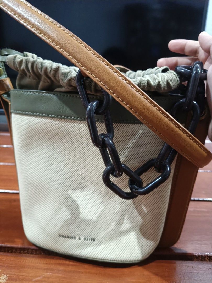 Charles & Keith Bucket Bag with Chain (Category: Luxury Bags & Wallets) located in Dagupan City. Submitted by sumiko091 (Listing ID 1435992766, Image 1). Description: - Charles & Keith bucket bag - Neutral canvas body - Brown leather accents - Black chain strap - Drawstring closure - Green interior - Includes long strap for shoulder/crossbody wear - Perfect for everyday use.