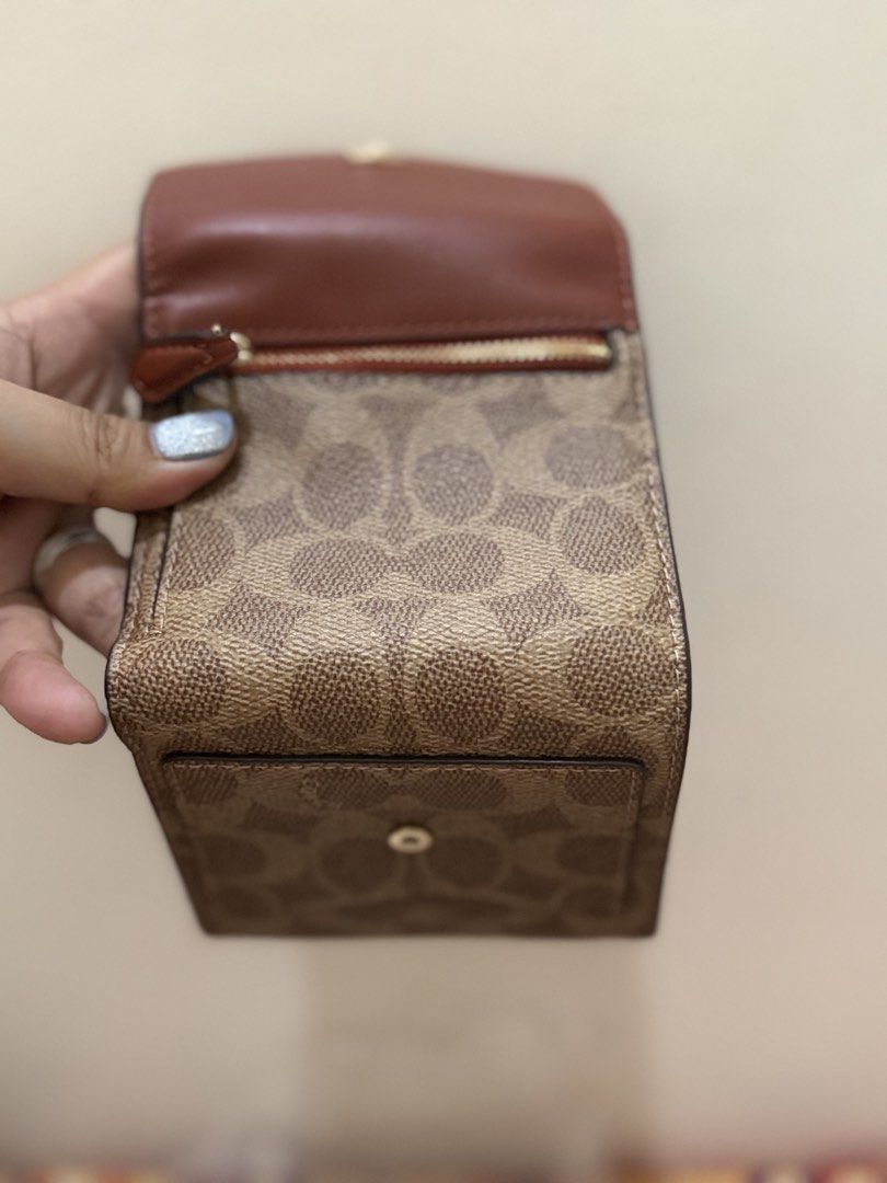 Coach Signature Small Wallet (Category: Luxury Bags & Wallets) located in Quezon City. Submitted by msaisa (Listing ID 1435952904, Image 2). Description: - Authentic Coach wallet - Signature C design - Brown and tan exterior - Red interior - Multiple card slots - Coin compartment - Includes original tags.
