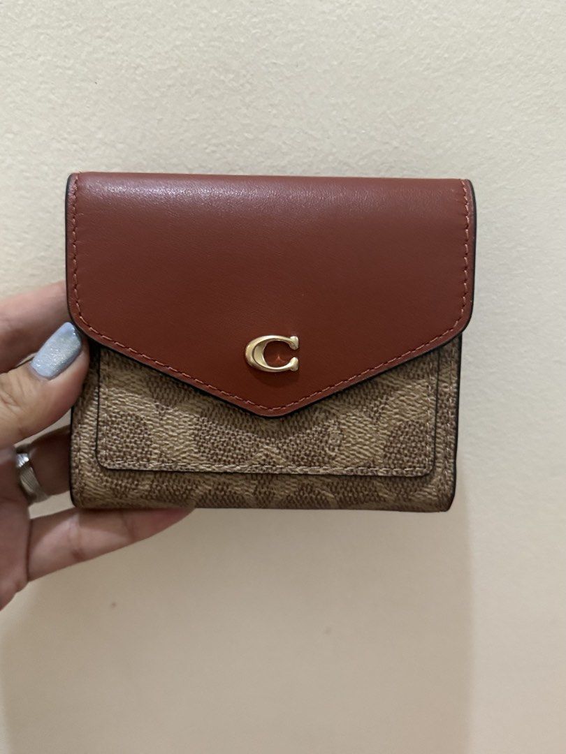 Coach Signature Small Wallet (Category: Luxury Bags & Wallets) located in Quezon City. Submitted by msaisa (Listing ID 1435952904, Image 1). Description: - Authentic Coach wallet - Signature C design - Brown and tan exterior - Red interior - Multiple card slots - Coin compartment - Includes original tags.