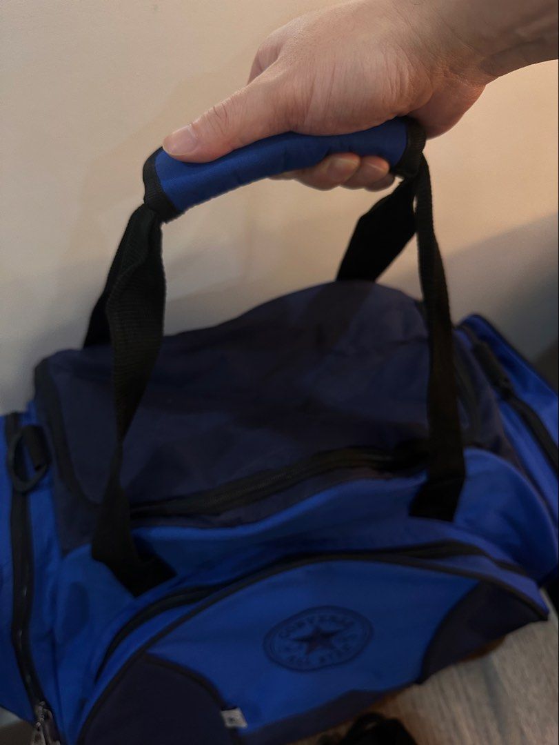 Converse All Star Duffle Bag (Category: Sling Bags) located in Caloocan City. Submitted by kween.of.decluttering (Listing ID 1436077648, Image 2). Description: - Converse All Star duffle bag - Color: Blue and Navy - Shoe pocket / compartment - Main compartment - Side pockets - Detachable shoulder strap - Top handle - Converse logo on front - Branded zippers - Multiple interior compartments.