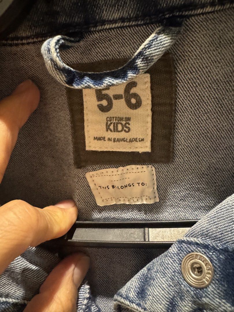 Cotton On Kids Denim Jacket (Category: Babies & Kids Fashion) located in Quezon City. Submitted by Tasi671 (Listing ID 1435997866, Image 3). Description: - Cotton On Kids denim jacket - Size: 5-6 - Light blue wash look (vintage look) - Classic design with button closures and pockets - Made in Bangladesh - Versatile for various outfits - Suitable for everyday wear SRP 2,500.