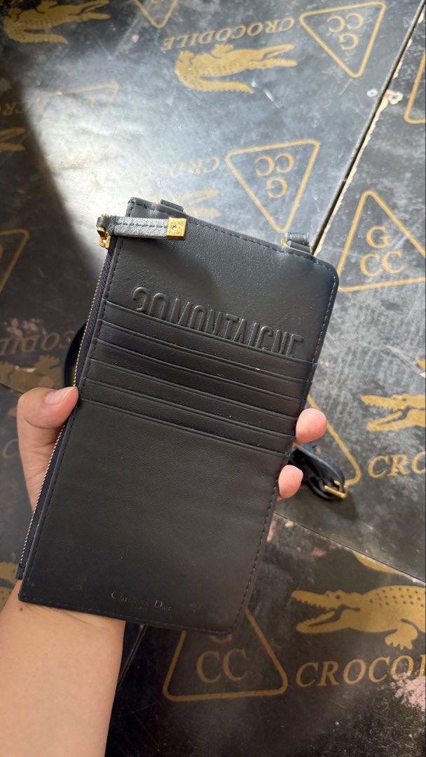 Dior Oblique Canvas Card Holder (Category: Luxury Bags & Wallets) located in Baguio. Submitted by yssia.10 (Listing ID 1435972856, Image 2). Description: - Dior Oblique card holder - Zip closure - Detachable strap - Interior card slots - Features "Christian Dior" logo - Gold-tone CD logo on front and strap - Stylish and functional accessory.