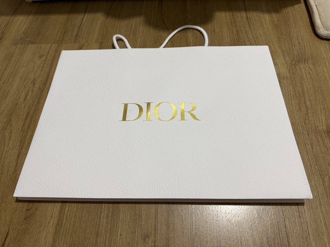 Dior Shopping Bag (Landscape) (Category: Craft Supplies & Tools) located in Valenzuela. Submitted by minami34 (Listing ID 1436030547, Image 2). Description: - Authentic Dior shopping bag - Features the Dior logo in gold - White textured paper - White rope handles - Gold bee interior logo - Perfect for gifting or collecting Dimensions: (L- 42.1cm x W- 30.1cm x D - 13.2cm) Reason for selling: Declutter Note: Shipping Fee (SF) still not included. Mo