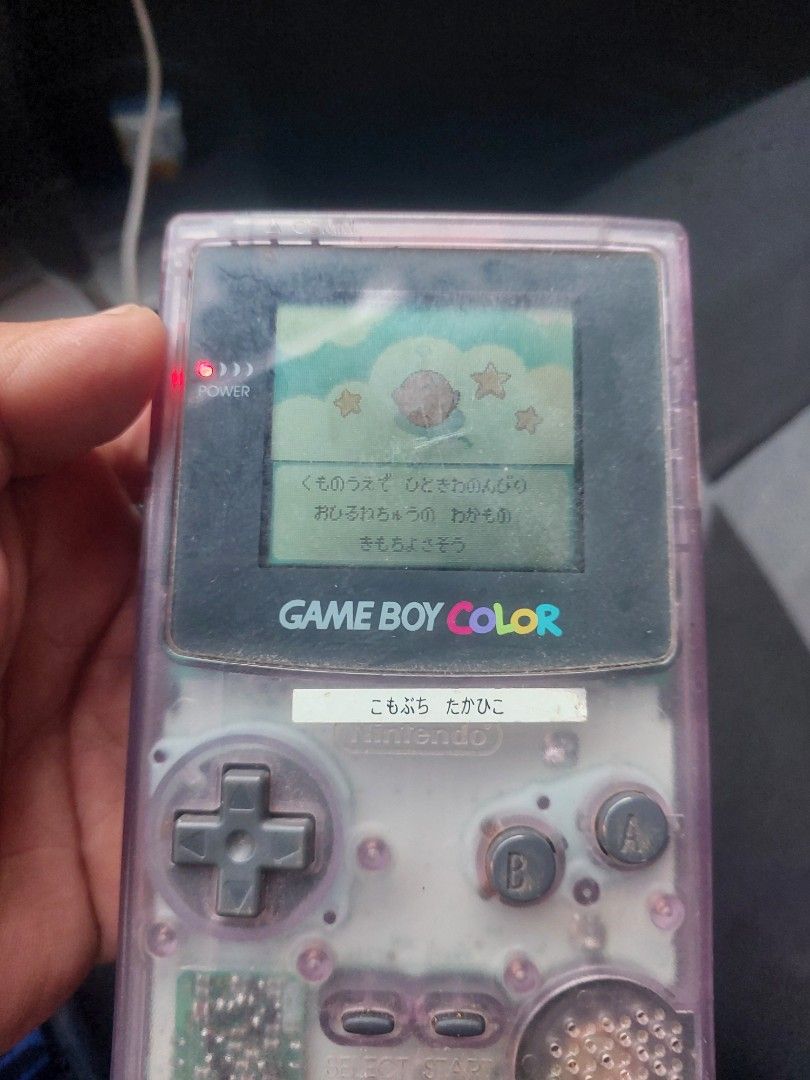 Game Boy Color - Clear Purple (Category: Nintendo) located in Quezon City. Submitted by jpnvintageonline (Listing ID 1435932962, Image 1). Description: - Game Boy Color in clear purple casing - Includes a game cartridge - Features visible buttons, D-pad, and screen - Shows the Game Boy Color logo - Battery compartment with batteries included - minor lcd issue .