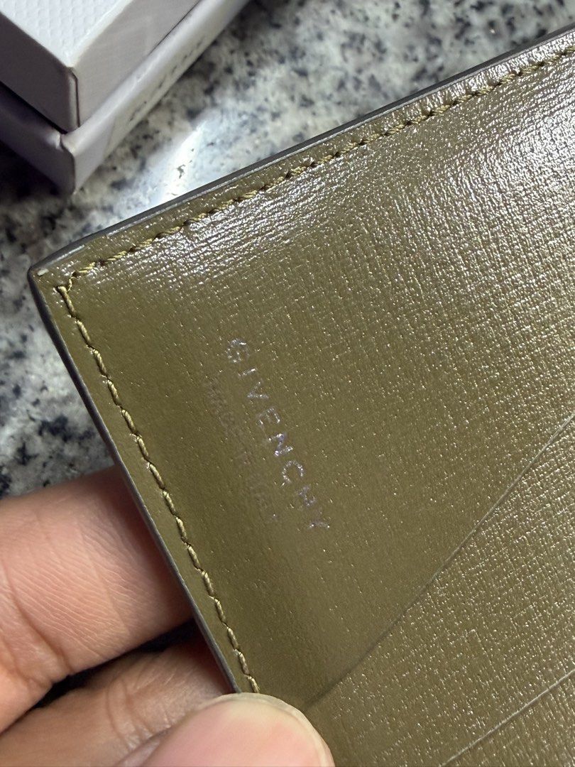 Givenchy Leather Wallet (Category: Luxury Bags & Wallets) located in Manila. Submitted by absalon2 (Listing ID 1435963295, Image 3). Description: - Givenchy leather wallet - Color: Gray - Includes: Original box, dust bag, and card - Features: - Multiple card slots - Bill compartment - Embossed Givenchy logo - Interior color: Olive green Issue: Faded silver Givenchy logo stamp .