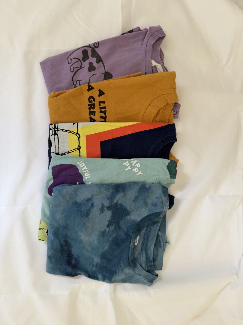 Kids' Graphic T-shirts Bundle 5-6 (Category: Babies & Kids Fashion) located in Marilao. Submitted by mebslerman (Listing ID 1435986274, Image 2). Description: - 5-piece set of kids' graphic t-shirts - Includes: - Purple shirt with pig design - Orange shirt with text - Navy shirt with colorful design - Light blue shirt with text - Tie-dye blue shirt - All shirts are short-sleeved..