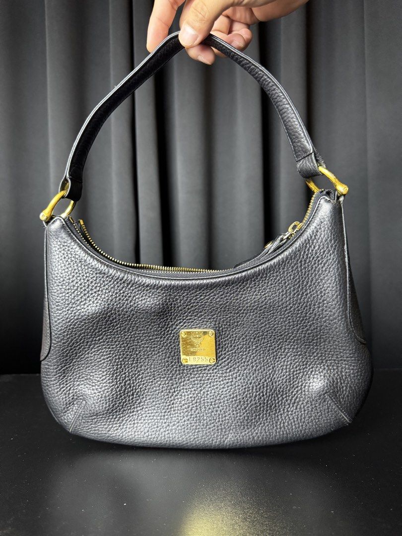 MCM Black Hobo Bag (Category: Luxury Bags & Wallets) located in Calamba. Submitted by maddy.cube (Listing ID 1436046521, Image 1). Description: - Black MCM hobo bag - Gold-tone hardware - Zip closure - Single shoulder strap - Interior zip pocket - MCM brand label - Textured leather finish - Gold MCM logo plate.