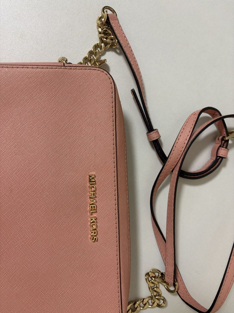 Michael Kors Pink Crossbody Bag (Category: Luxury Bags & Wallets) located in Manila. Submitted by na.serr (Listing ID 1436030686, Image 3). Description: - Authentic Michael Kors crossbody bag - Color: Pink - Gold chain strap - Zip closure - Includes shoulder strap - Gold Michael Kors logo on front - Textured material.