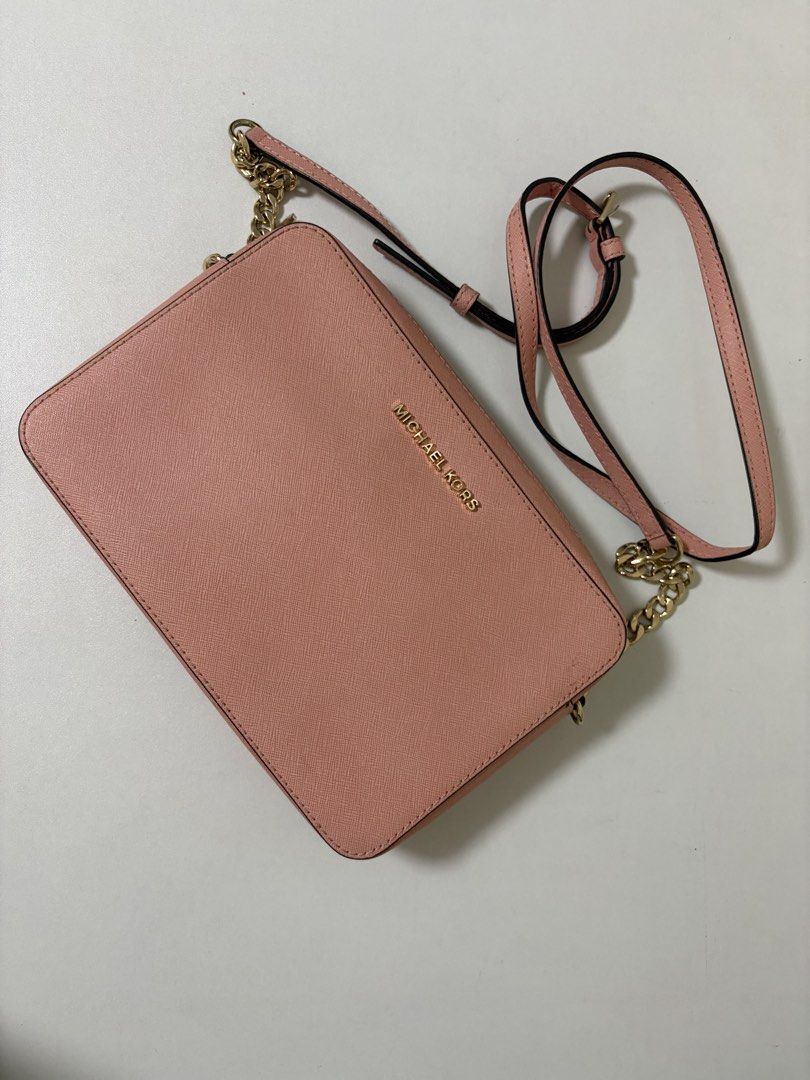 Michael Kors Pink Crossbody Bag (Category: Luxury Bags & Wallets) located in Manila. Submitted by na.serr (Listing ID 1436030686, Image 1). Description: - Authentic Michael Kors crossbody bag - Color: Pink - Gold chain strap - Zip closure - Includes shoulder strap - Gold Michael Kors logo on front - Textured material.