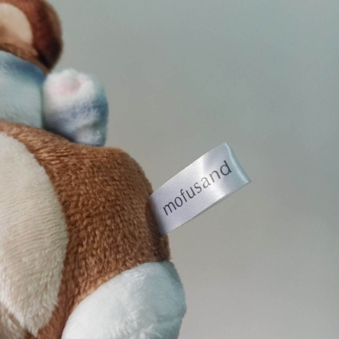 Mofusand Cat in Monkey Costume Plush Charm (Category: Plushies & Soft Toys) located in Noveleta. Submitted by forgetti00 (Listing ID 1435916316, Image 3). Description: Adorable Mofusand cat plushie wearing a monkey costume. Features a cute embroidered face with big eyes and a small pink nose. The plush has a soft, brown and beige color scheme. Includes a tag that says "mofusand". Perfect for cat lovers and collectors..