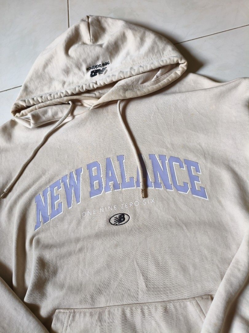 New Balance Hoodie (Category: Hoodies) located in Manila. Submitted by kantoarchives (Listing ID 1436053842, Image 2). Description: - Cream-colored New Balance hoodie - Light purple arched brand logo - Front kangaroo pocket - Drawstring hood - Ribbed cuffs and hem - Medium-weight cotton blend fabric.