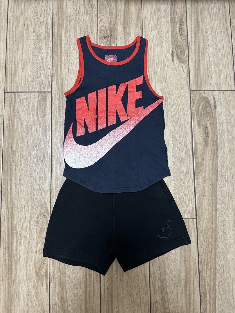 Nike Tank Top and Shorts Set (Category: Activewear) located in Manila. Submitted by sircee6 (Listing ID 1436045302, Image 1). Description: - 3-5 y/o as pack includes a navy blue Nike tank top with a red and white Nike logo and a pair of black shorts. The tank top has red trim around the neckline and armholes. The shorts have a small design on the left leg. This set is perfect for casual wear or workouts..