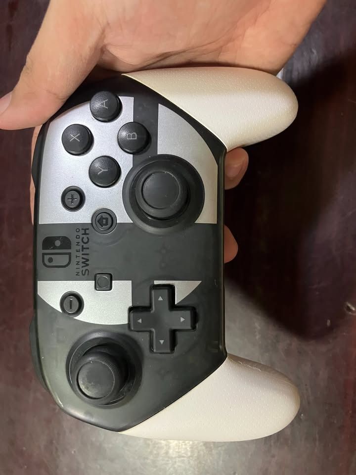 Nintendo Switch Pro Controller (Category: Controllers) located in Marikina City. Submitted by lasgna (Listing ID 1436063335, Image 2). Description: FOR SALE AS A BUNDLE ONLY - Nintendo Switch Pro Controller - Unique black and white design - Includes a carrying case - Standard button layout - Analog sticks - USB-C charging port Issues: - Left Joycon connection issues - Cosmetic Issue No other issues. Payment via Gcash, Maya, Gotyme Buyer shoulders