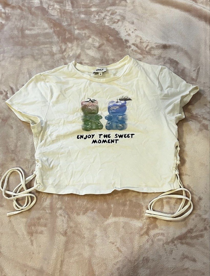 Only Gummy Bear Graphic T-shirt (Category: Shirts) located in Naga. Submitted by lovedby.christineee_ (Listing ID 1435913839, Image 1). Description: - Only white t-shirt - Gummy bear graphic print - Side ties for adjustable fit - Short sleeves - Lightweight material.