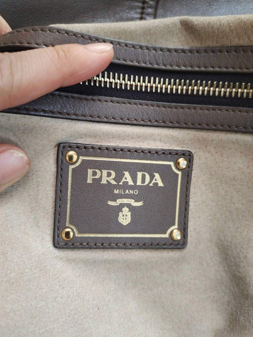 Prada Hobo Bag (Category: Luxury Bags & Wallets) located in Cebu City. Submitted by tlisurplus (Listing ID 1435921705, Image 2). Description: - Authentic Prada hobo bag - Gray leather exterior - Gold-tone hardware - Zipper closure - Includes Prada label and small tag - Made in China.