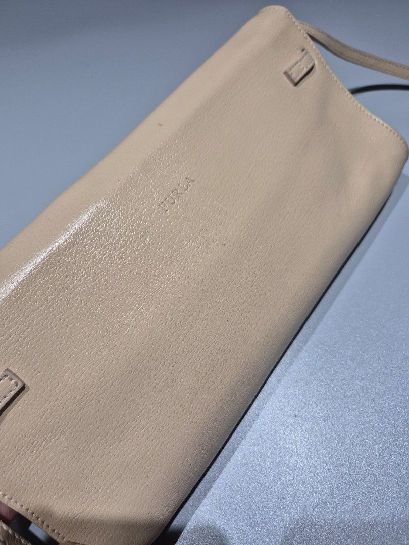 Preloved Furla Clutch Sling Bag (Category: Clutches) located in Tarlac. Submitted by mygarangesale (Listing ID 1436083148, Image 3). Description: Condition: Leather in good condition, with barely noticeable small spot stains fr the outside, meron din sya stain sa loob as you can see sa photo. detachable leather sling size: 30cm width 16cm ht, 45cm sling ht fr shoulder. Design: A sleek, rectangular silhouette with a foldover flap. Material: Graine