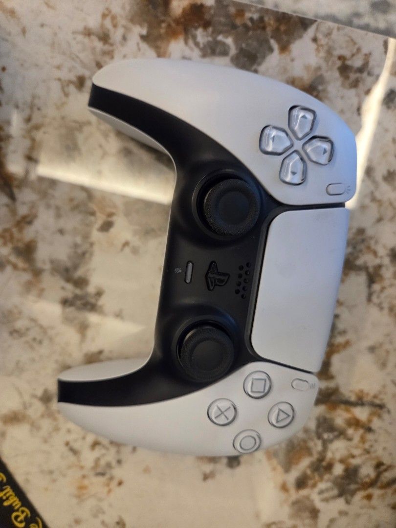 PS5 Disk Version (Category: PlayStation) located in Shah Alam. Submitted by sharnazzz (Listing ID 1435914571, Image 3). Description: - PlayStation 5 console (white and black) - Includes two controllers: - One white - One camouflage - Charging station included - Charging station charges two controllers simultaneously - Console is shown in a vertical position - Cables Bonus (Give away with purchase) (1)Assasin Creed Shadow Disk Version Note: Single