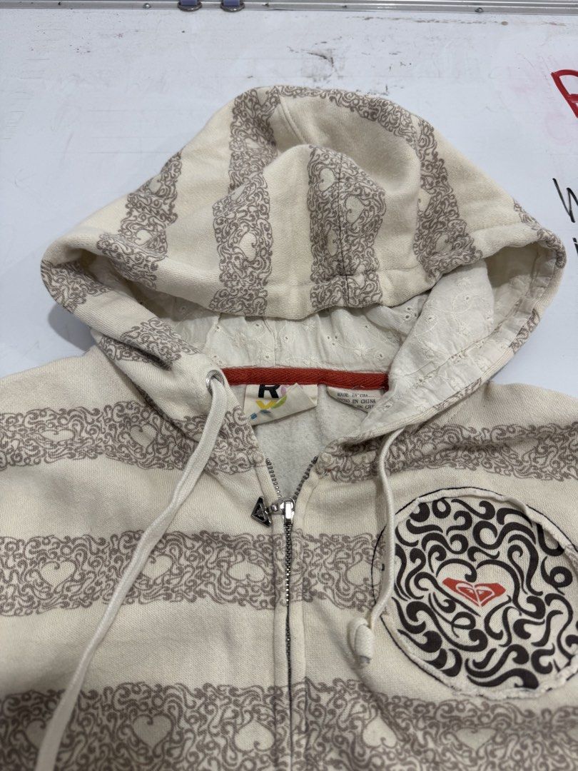 Roxy Y2K Striped Hoodie (Category: Coats, Jackets and Outerwear) located in Cebu City. Submitted by oryenz (Listing ID 1435996954, Image 3). Description: - Roxy Y2K hoodie - Size: S/CH - Features: - Striped pattern - Zip-up front - Hood - Brown hem and cuffs - Embroidered Roxy logo on the back - Measurements: - Width: 17 inches - Length: 21 inches.