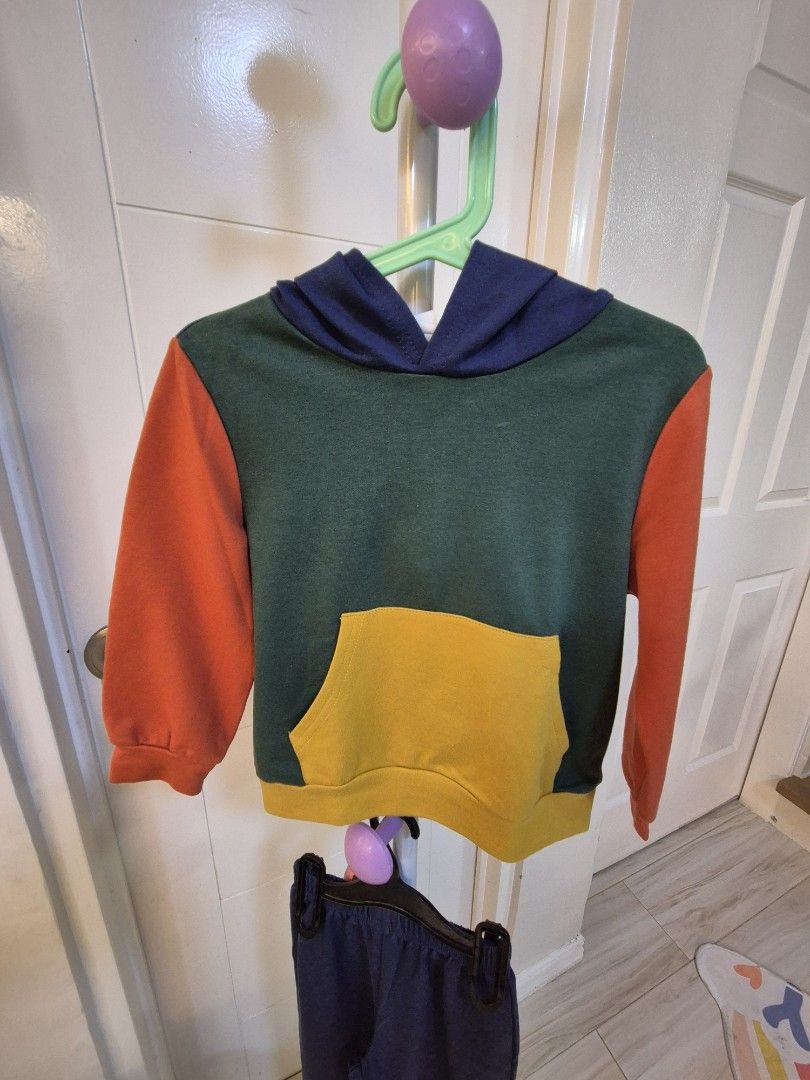 Shein 4Y Colorblock Sweatshirt and Pants Set (Category: Babies & Kids Fashion) located in Bacoor. Submitted by amdeocampo (Listing ID 1435920764, Image 2). Description: - Shein 2-piece outfit, size 4Y. - Sweatshirt: - Green body - Yellow pocket - Orange sleeves - Navy blue hood - Pants: Navy blue with yellow cuffs. - Ideal for everyday wear. Pre-loved items, please manage your expectations. There may be slight discoloration due to washing and/or 