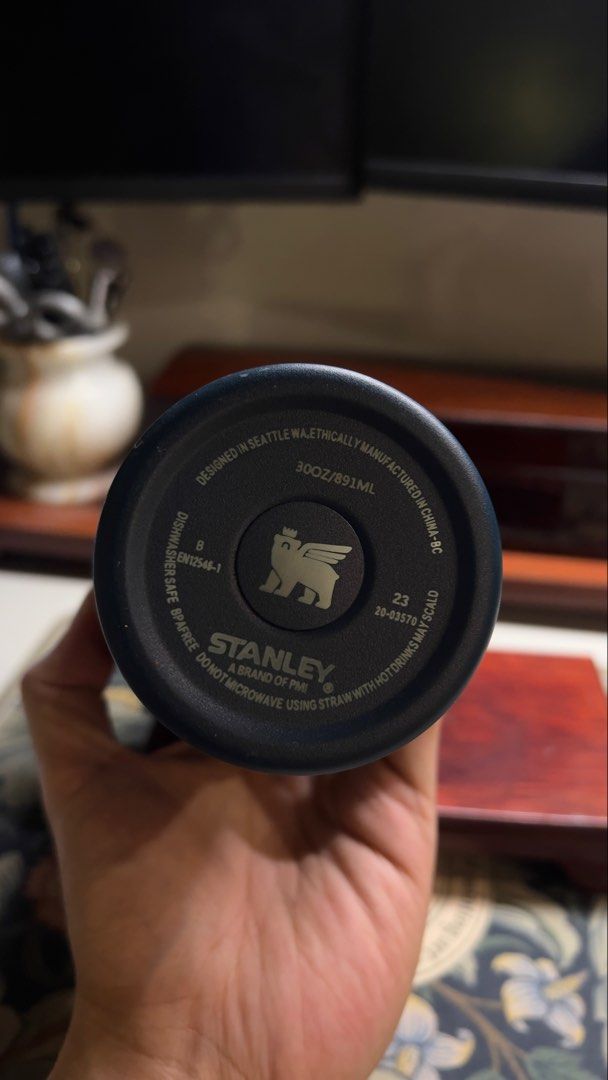 Stanley Quencher H2.0 FlowState Tumbler 30oz (Category: Water Bottles & Tumblers) located in Paranaque City. Submitted by btslite (Listing ID 1436087721, Image 2). Description: Stanley Quencher H2.0 FlowState Tumbler is a 30oz tumbler. It features a navy blue body with a brown lid and handle. The tumbler includes a straw and is designed in Seattle, WA. The bottom of the tumbler indicates it is manufactured in China. It is dishwasher safe and BPA-