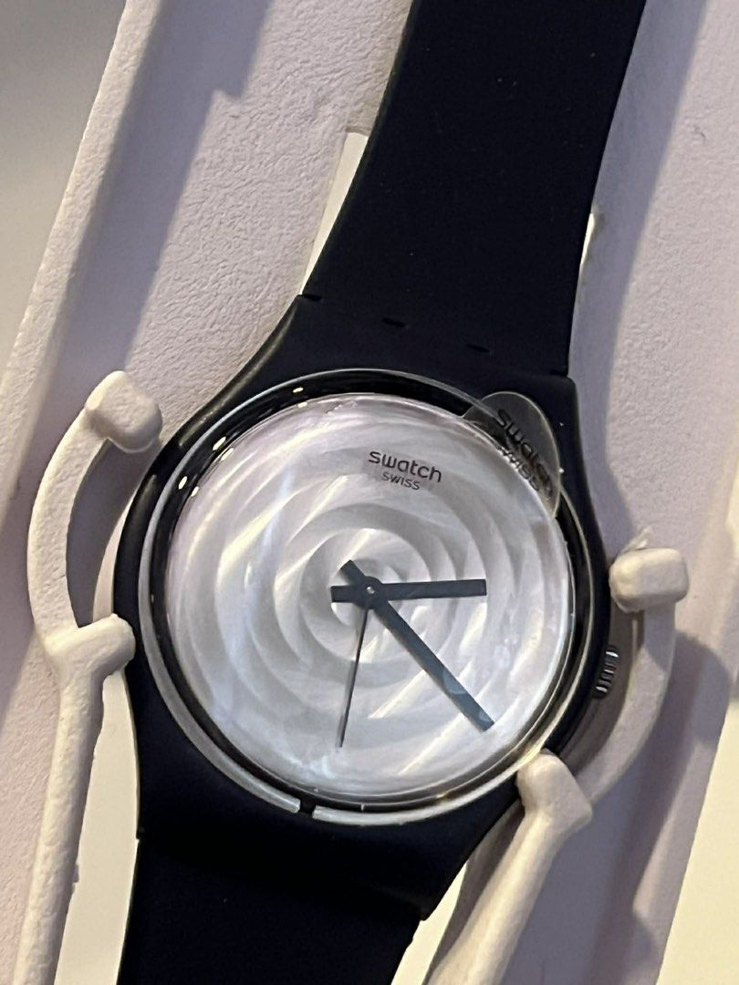 Swatch Swiss Watch (Category: Women's Watches) located in Manila. Submitted by declutter_with_cmb (Listing ID 1435957255, Image 1). Description: Swatch Swiss watch features a navy/black strap and a unique spiral design on the watch face. The watch has a black bezel and a clear protective film on the watch face. The watch hands are black. The watch is in its original packaging..