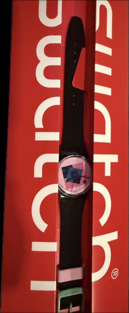 Swatch Watch (Category: Women's Watches) located in Manila. Submitted by declutter_with_cmb (Listing ID 1435954646, Image 1). Description: - Swatch watch with a unique pink and blue geometric design. - Features a black strap with a pink loop and a green buckle. - Includes the original red Swatch box..
