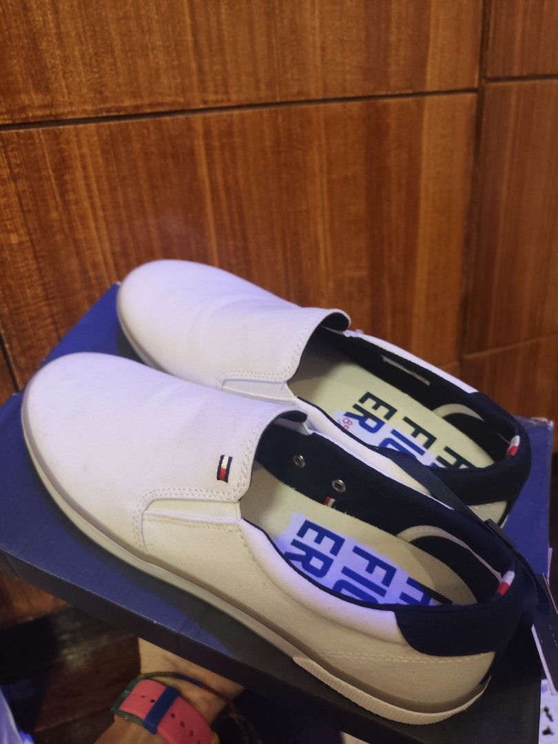 Tommy Hilfiger Slip-on Shoes (Category: Sneakers) located in Manila. Submitted by margamarti35560 (Listing ID 1436087278, Image 2). Description: - Tommy Hilfiger slip-on shoes - White color - Navy blue trim - Brand logo on side and insole - Includes original box and tags - Classic and versatile design.