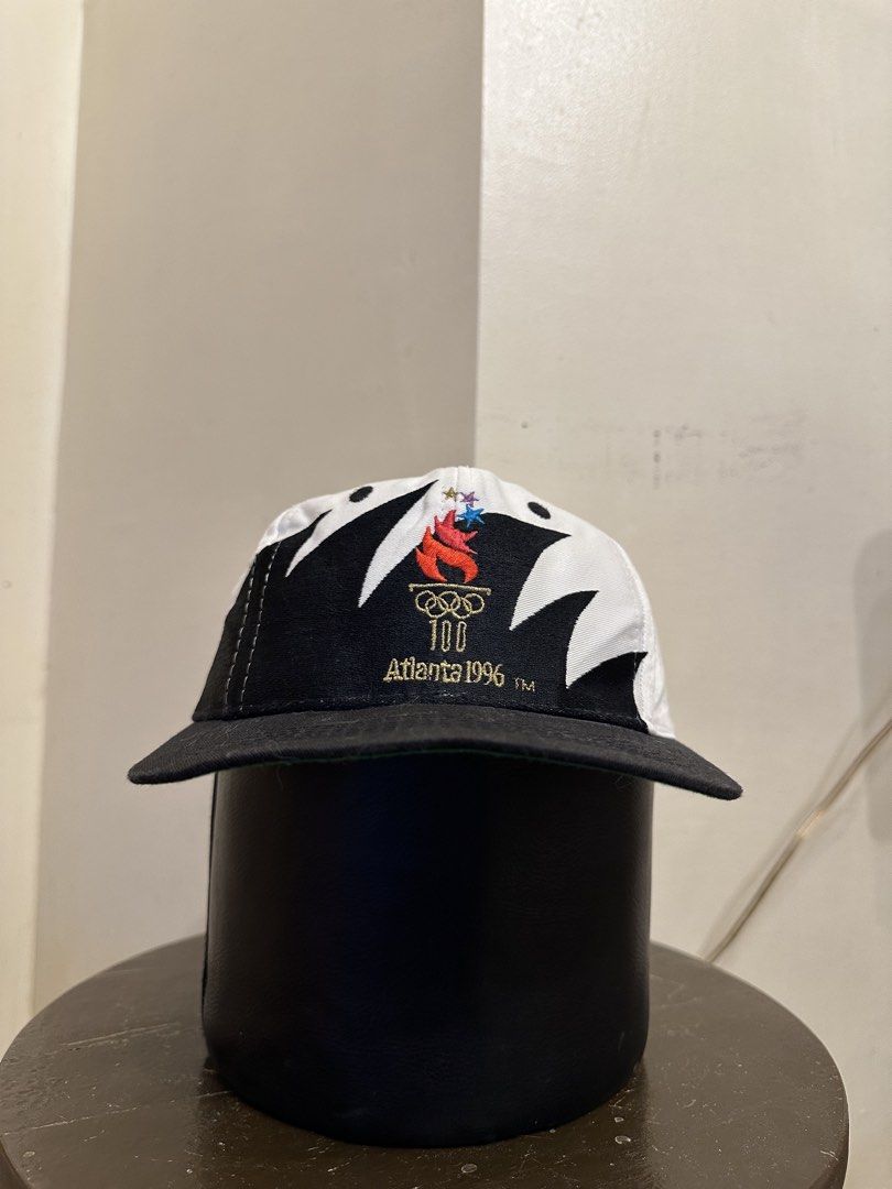 Vintage Stooth Atlanta 1996 Olympics Cap (Category: Caps & Hats) located in Bacoor. Submitted by realbacktrack (Listing ID 1435992443, Image 1). Description: - Vintage Atlanta 1996 Olympics cap -Small head frame - Embroidered Olympic torch logo - Black brim - White crown with black accents - Adjustable strap for a comfortable fit - Green lining - Includes original tag *hairlines on snap .