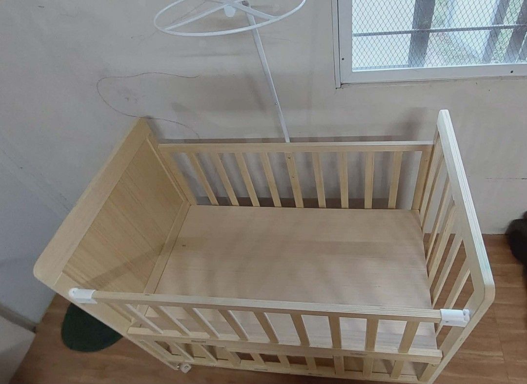 Wooden Baby Crib with Storage (Category: Cots & Cribs) located in Tarlac. Submitted by ladymama11 (Listing ID 1436071164, Image 2). Description: - Wooden baby crib with convertible design: crib, extended bed, and cradle modes. - Includes free gifts: bed-rest, pillow, mattress, bed surround cloth, and mosquito net. - Features a convenient storage drawer. - Made of light-colored wood. - Simple and classic design. rfs. already switch to playpen boug
