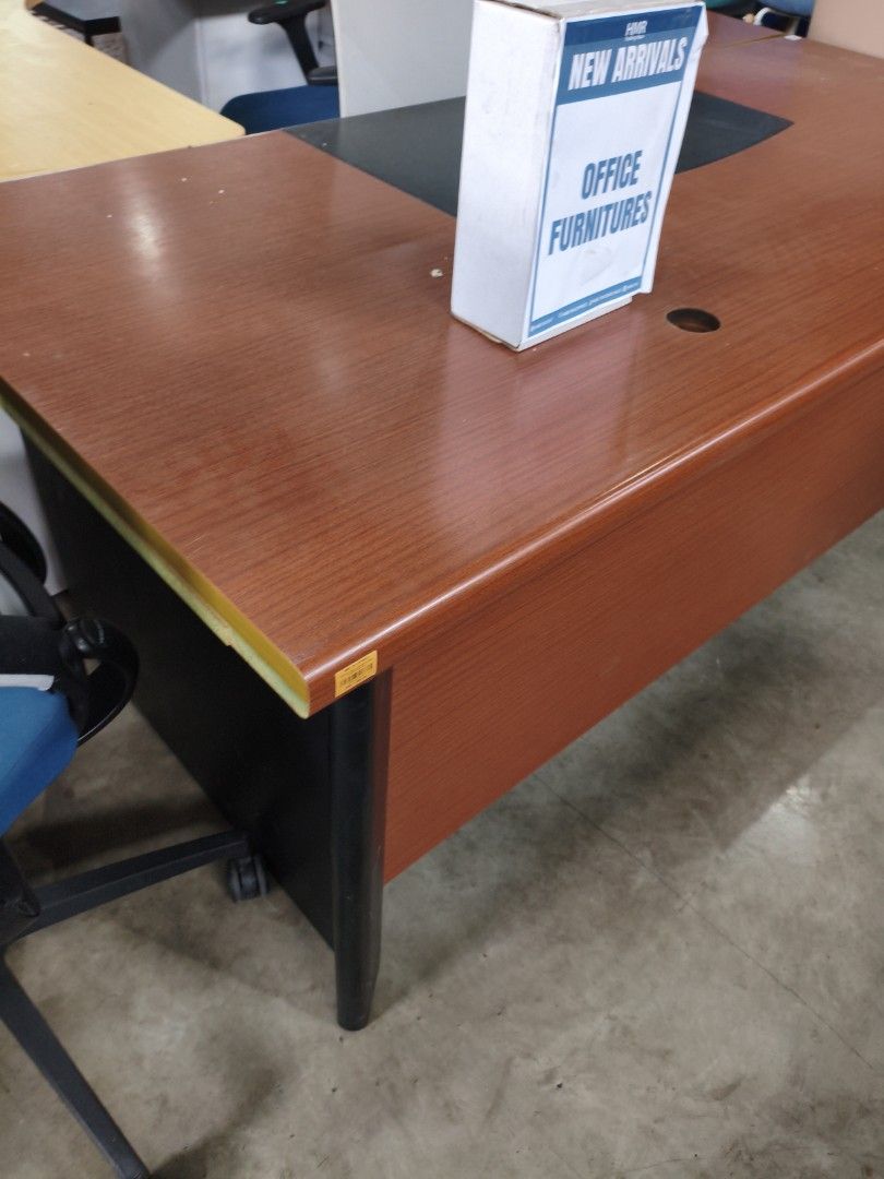 Wooden Office Table (Category: Office Furniture & Fixtures) located in Manila. Submitted by hmrgrace5. (Listing ID 1435945690, Image 3). Description: - Dark brown wooden office table - Features a curved section - Includes two holes on the surface - Black base - Price: ₱5,999.00 - Perfect for office use.
