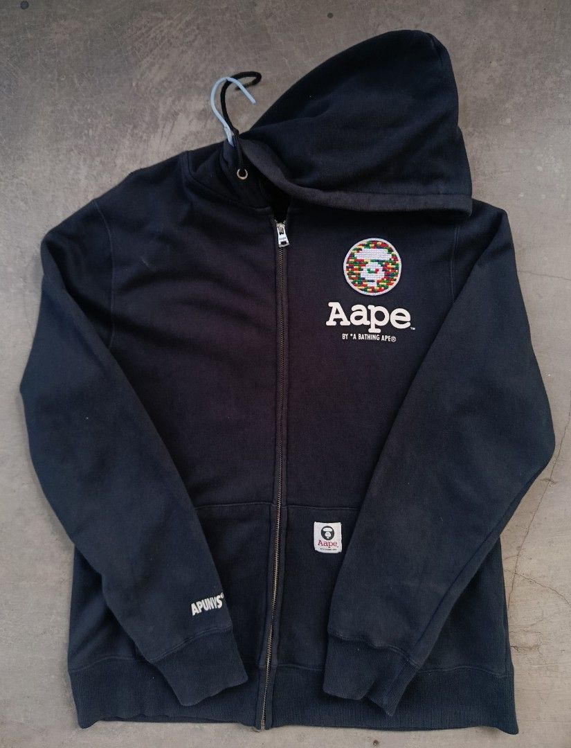 Aape by A Bathing Ape Zip-Up Hoodie (Category: Coats, Jackets and Outerwear) located in Manila. Submitted by dredvillag58696 (Listing ID 1436168733, Image 2). Description: DIMES: W20 L27 ISSUE : CUT NECKTAG COLOR RATE 9/10 - Aape by A Bathing Ape black zip-up hoodie. - Features a front logo patch. - Small Aape logo on the pocket. - Aape logo printed on the back. - Aape logo zipper pull. - Hood with drawstrings. - Two front pockets..