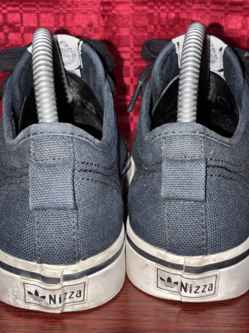Adidas Nizza Low Top Sneakers (Category: Sneakers) located in Placer. Submitted by talaalond61563 (Listing ID 1436205798, Image 3). Description: - Adidas Nizza low-top sneakers - Dark blue color - Adidas logo on tongue, side, and heel - White sole - Black laces - Shows some wear on soles - Adidas branding on insole.