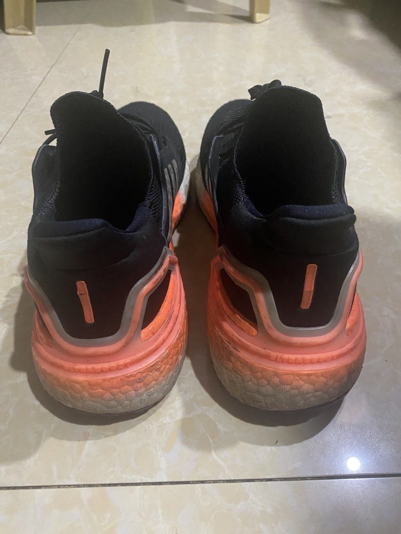 Adidas Ultraboost 20 Black Orange (Category: Sneakers) located in Manila. Submitted by decluttering_007 (Listing ID 1436101807, Image 3). Description: Negotiable Signs of use, intact. Ready to use Adidas Ultraboost 20 sneakers in black with orange accents. Features the iconic three stripes on the sides. The soles show some wear. The shoes have black laces and a breathable knit upper. The heel counter is orange. The boost midsole is visible..